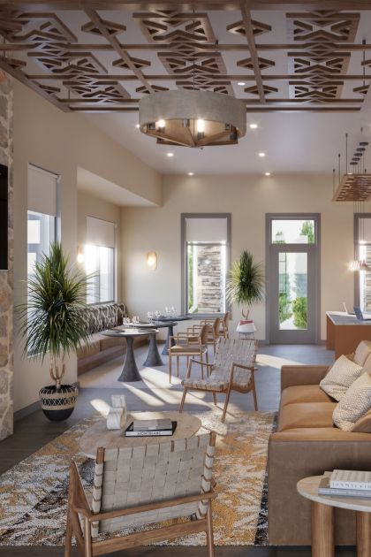 Everstone in Phoenix, AZ, clubroom with a stone fireplace, comfortable lounge seating, dining tables, and a private work area.