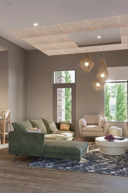 Everstone in Phoenix, AZ, clubroom with a green sectional, lounge seating, dining area, and large windows overlooking the landscaped grounds.